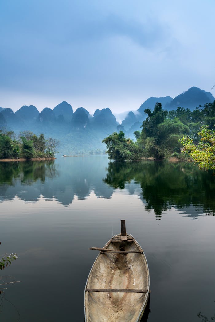 why-choose-us A tranquil river scene with a canoe, misty mountains, and lush greenery, perfect for nature lovers.